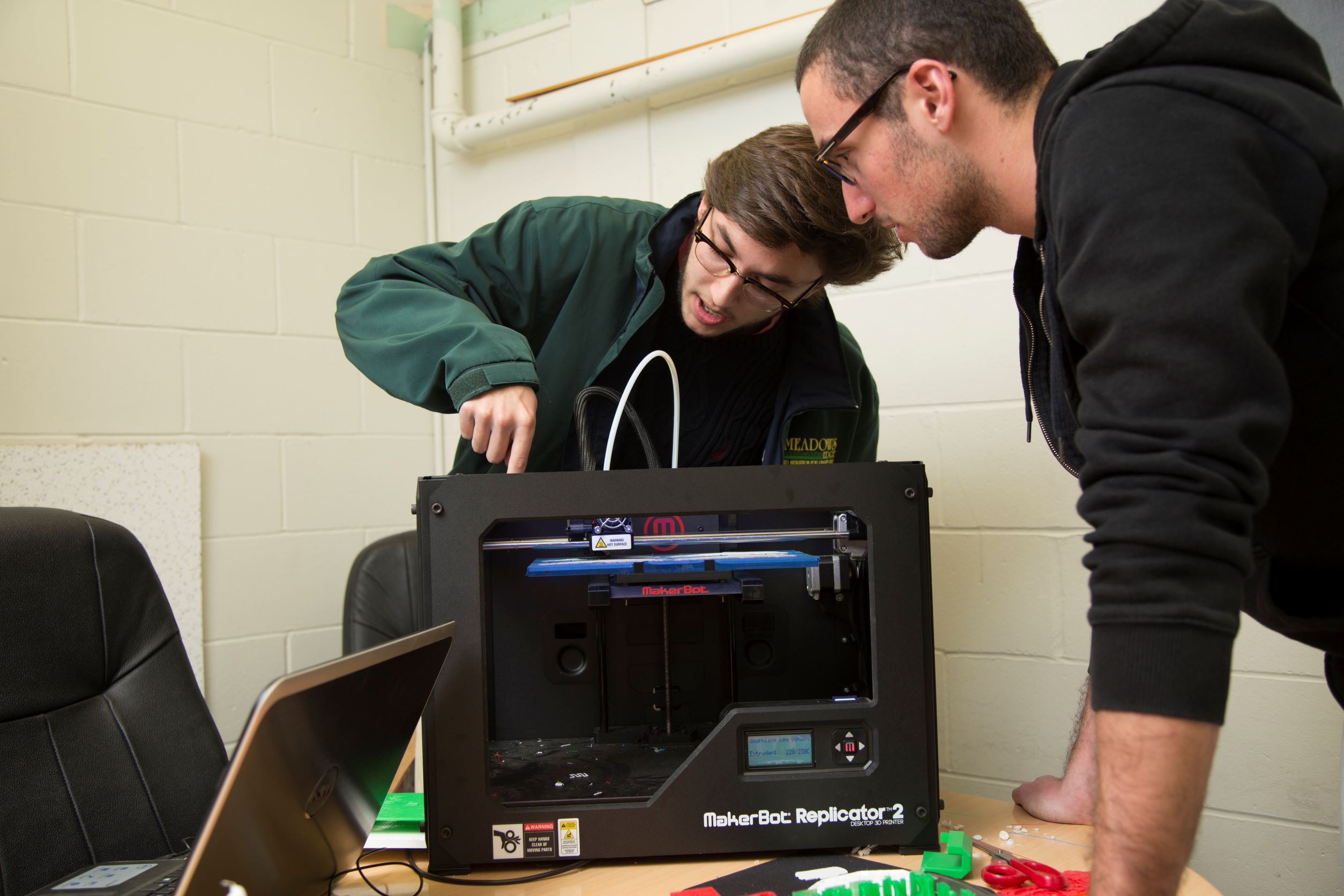 Two engineering students working on a replicator machine.