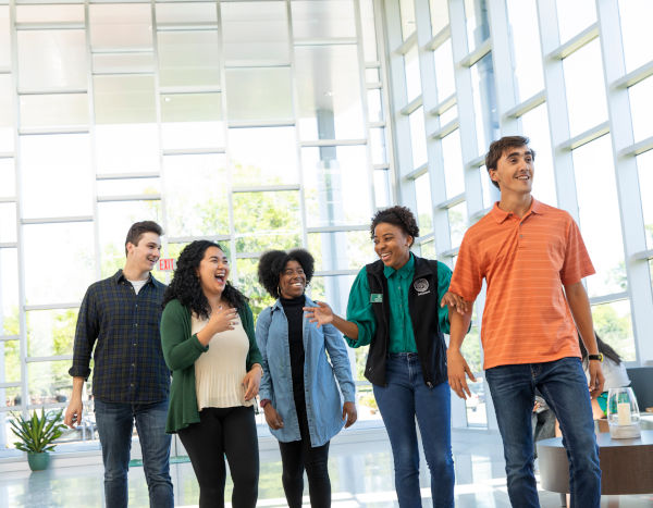 A group of students and a JU employee smiling and walking together.