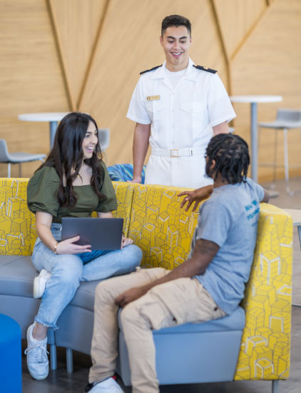 Three students chatting and smiling at each other.