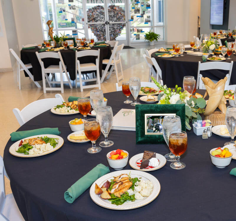 A photo of a table setting with plates, silver wear, napkins, food and drinks