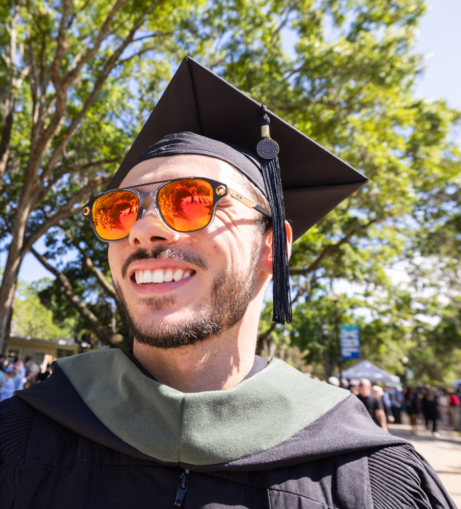 A student dressed in graduating regalia