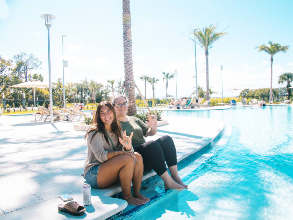 students seating by the River House pool
