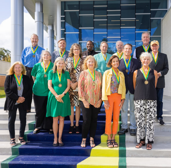 A group of 1974 JU alumni posing for photo in front of a Frish Welcome Center