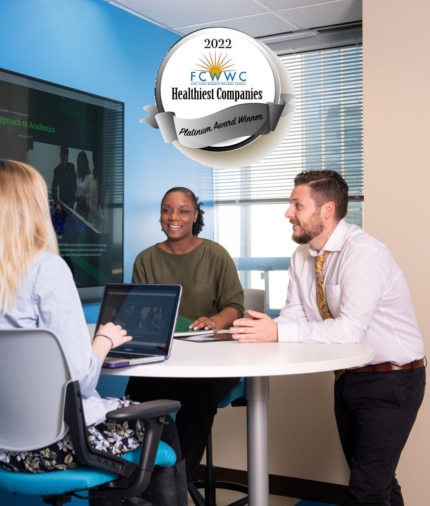 People seating around an office table and a FCWWC seal behind them.