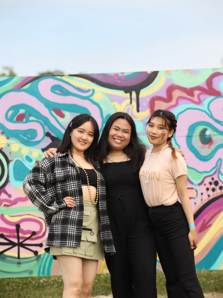 Group of exchange students in front of a colorful mural.