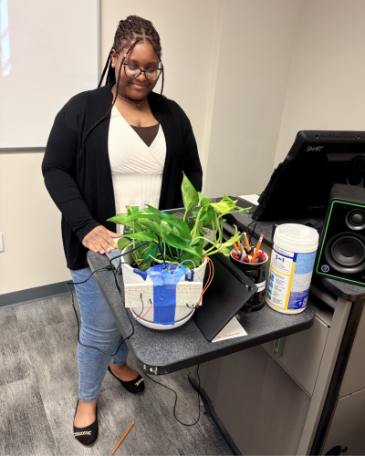 Student from Team Rooted future standing with project