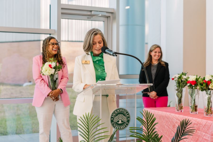 Stephanie Cost giving an acceptance speech at a podium.