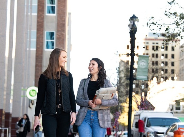 Two female JU students walking in Downtown Jax in discussion