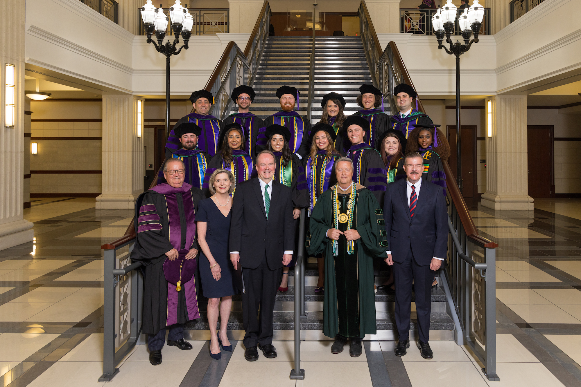 law students stand on stairs for formal portrait