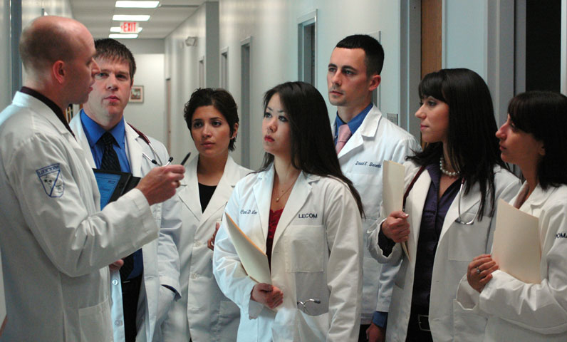 Doctor instructing doctoral students in a hallway