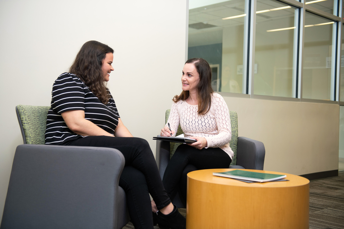 A female student sitting and speaking with a counseling professor.