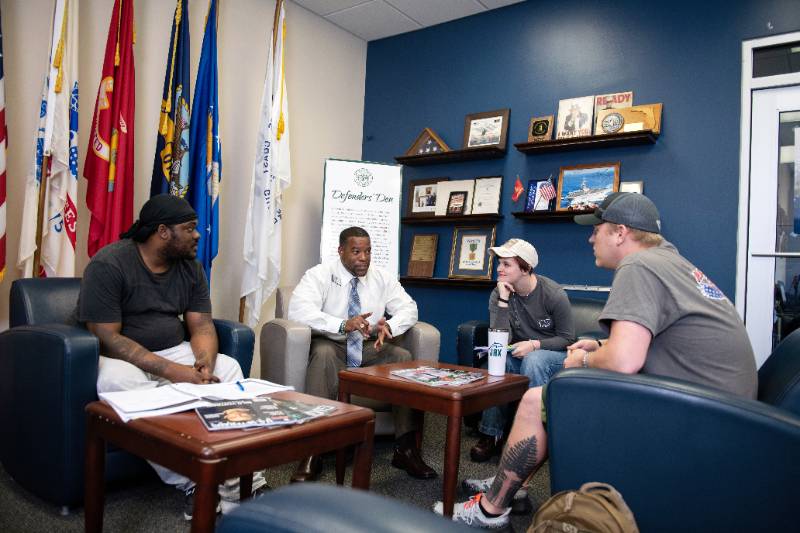 Veteran students talking with each other in the lobby of the Defenders Den on campus.