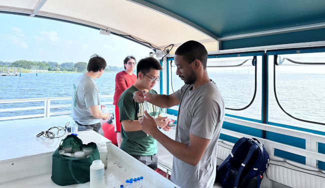a group of marine biology students on a boat doing research at sea
