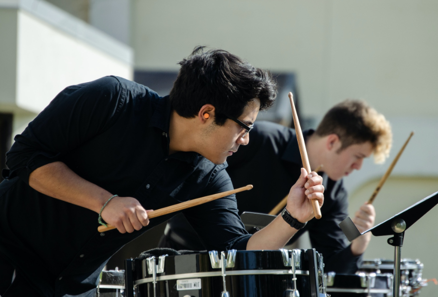 Music students in the percussion section playing the drums.