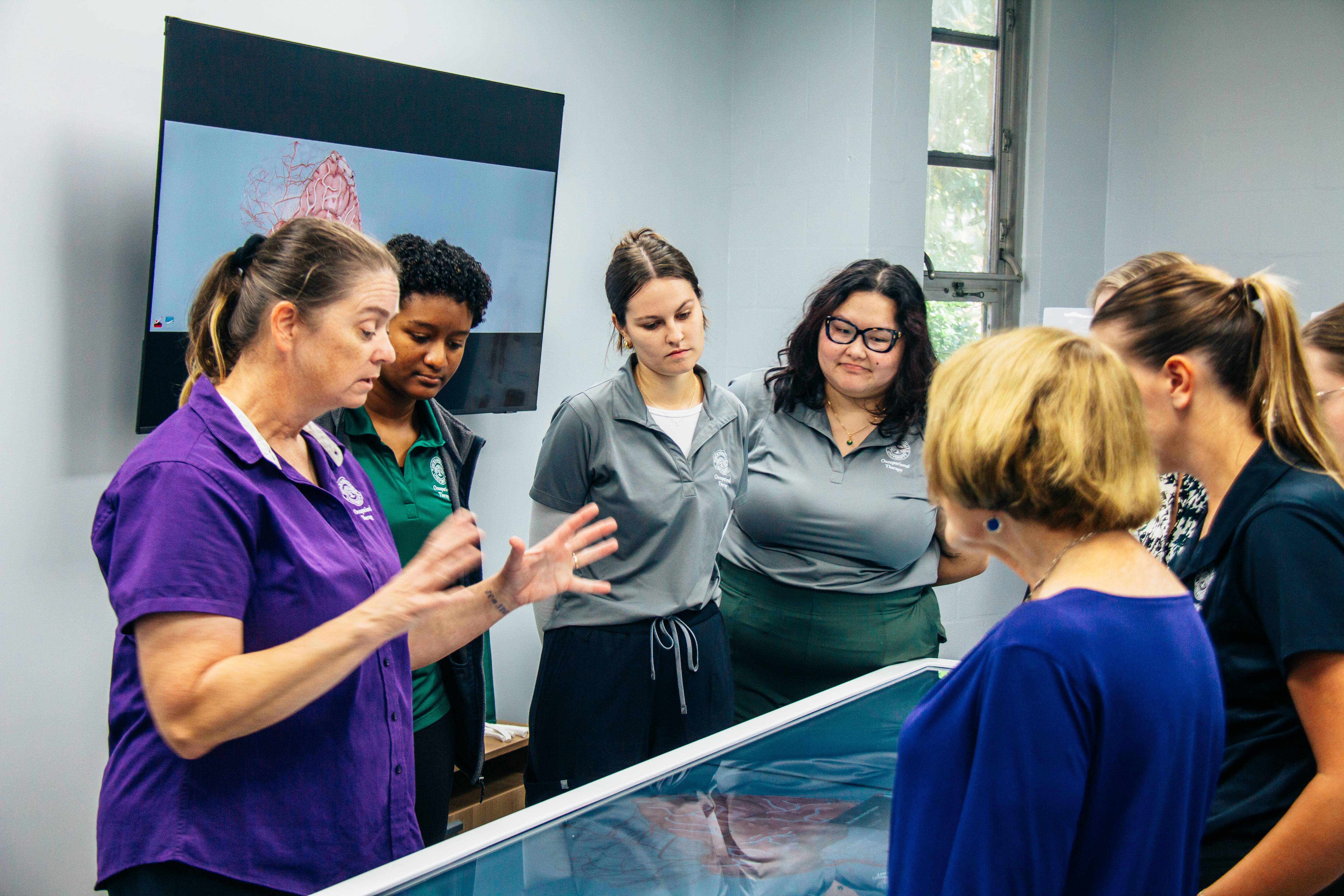 Students and faculty around anatomage table