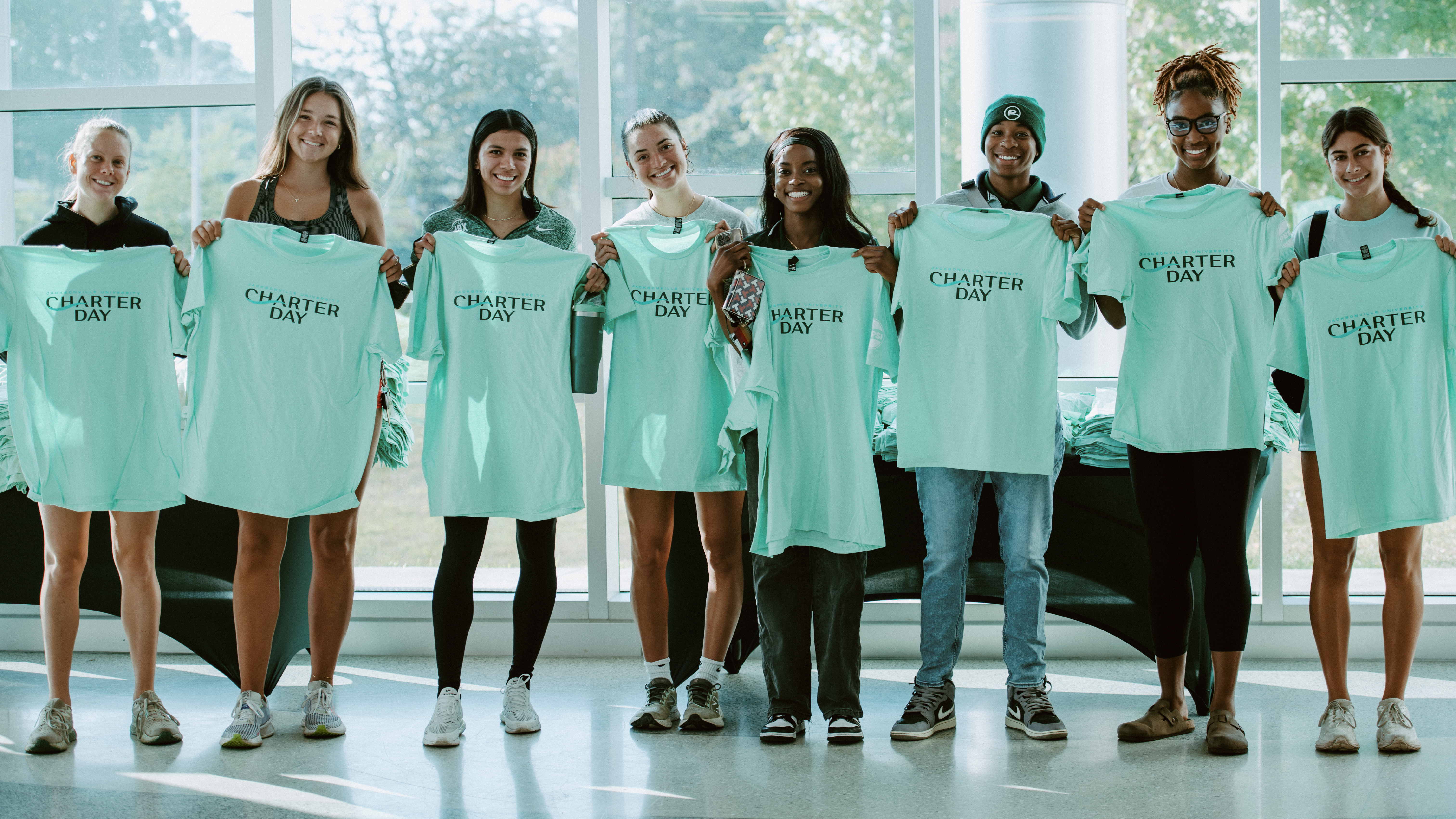 Students hold up Charter Day t-shirts