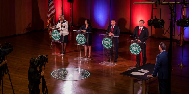 The candidates of the Jacksonville mayoral race at their podiums on stage.