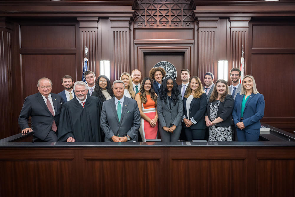 Fourteen students in the JU College of Law stand with JU President Tim Cost, Dean Allard, and Chief Judge Mahon. 