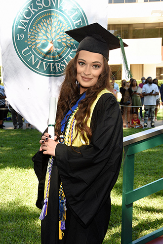 Allison Ventrone standing with her diploma after a graduation ceremony.