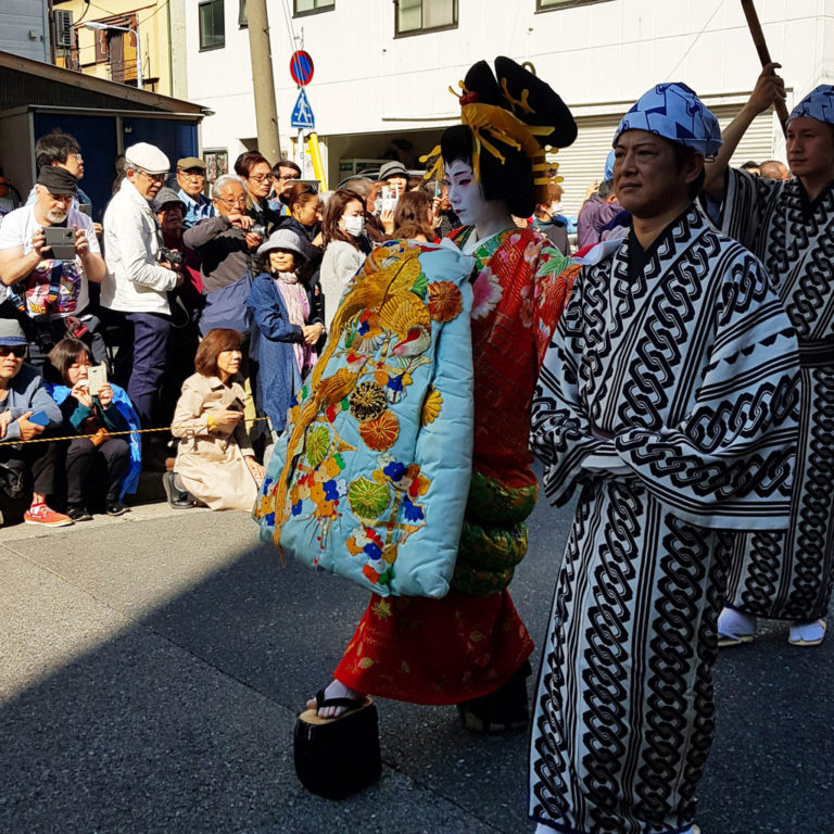 Japanese reenactment where woman is escorted down the street