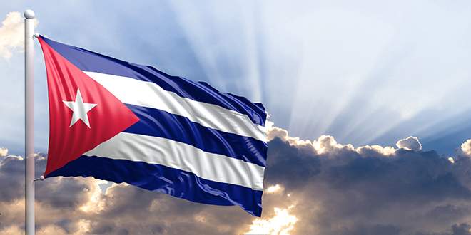 The Cuban flag in front of the sky.