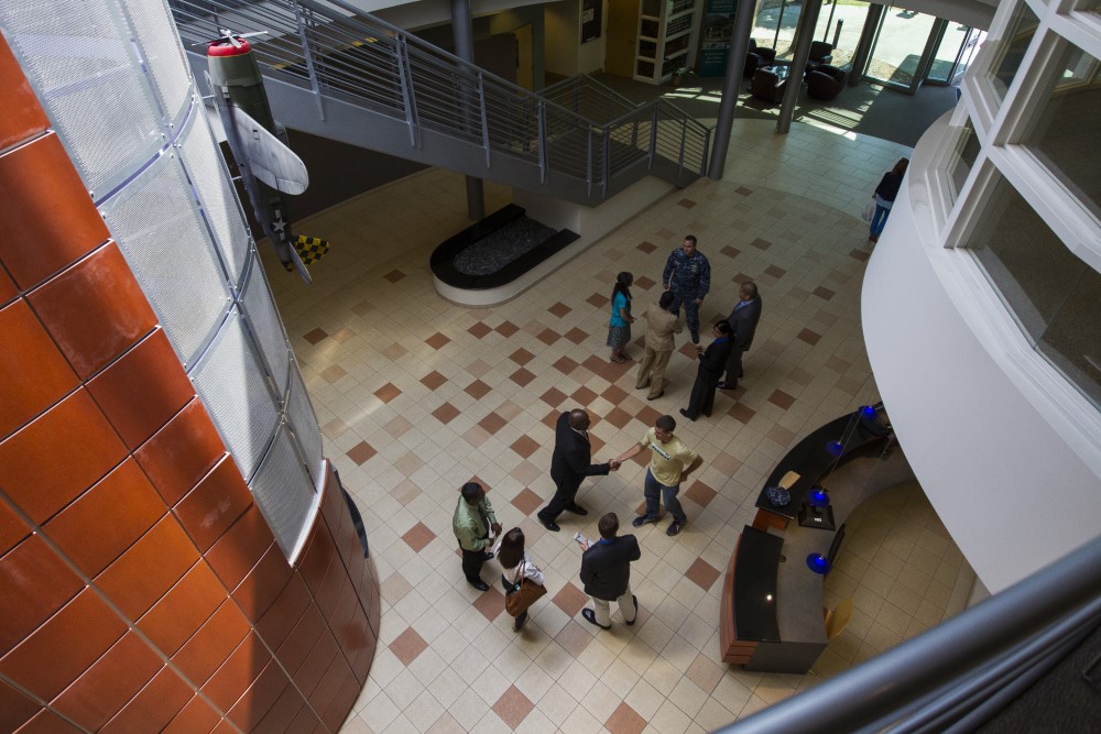 birds eye view of several individuals meeting in the JU Davis College of Business building lobby and networking during an event