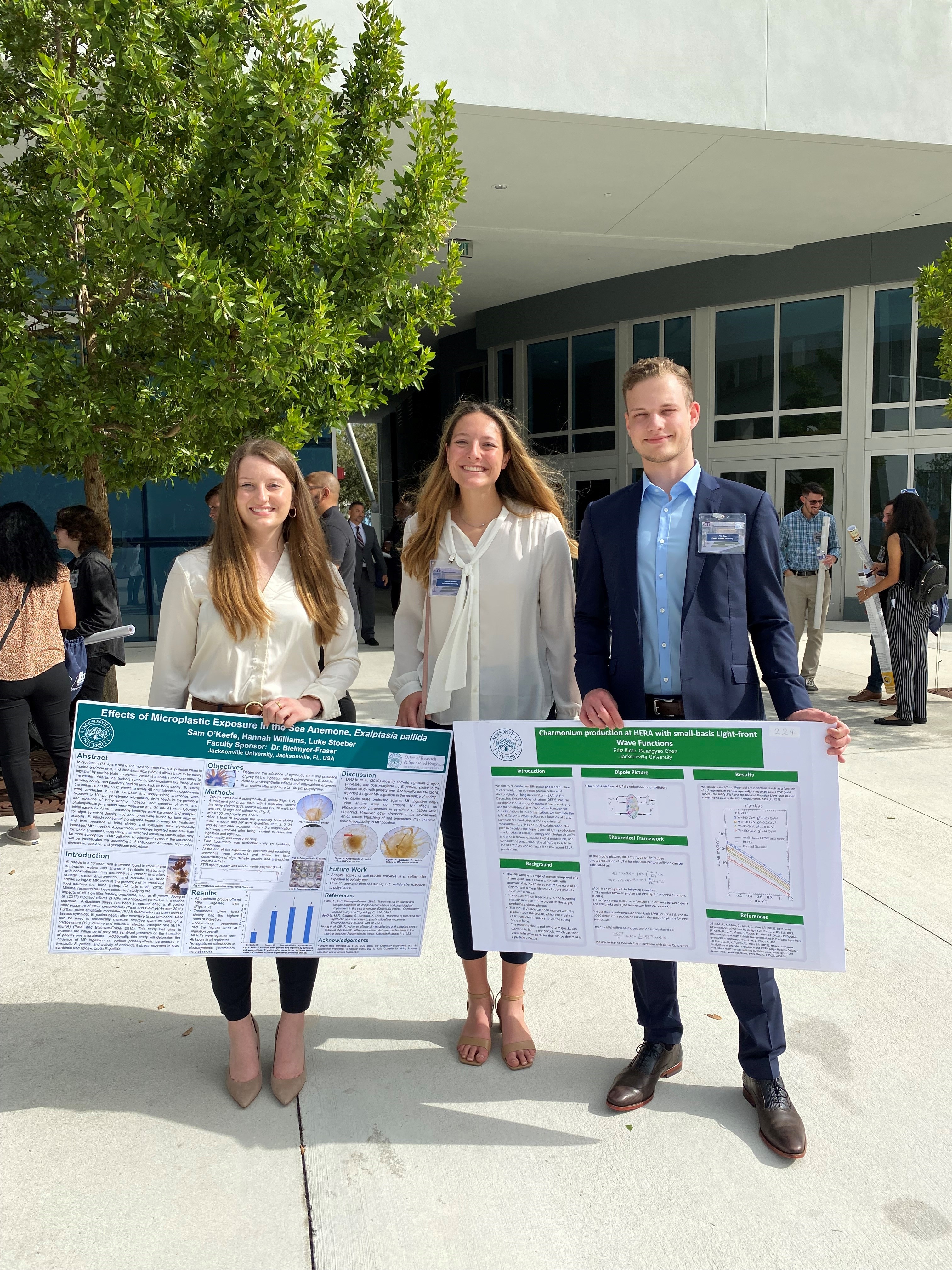 students pose with research posters