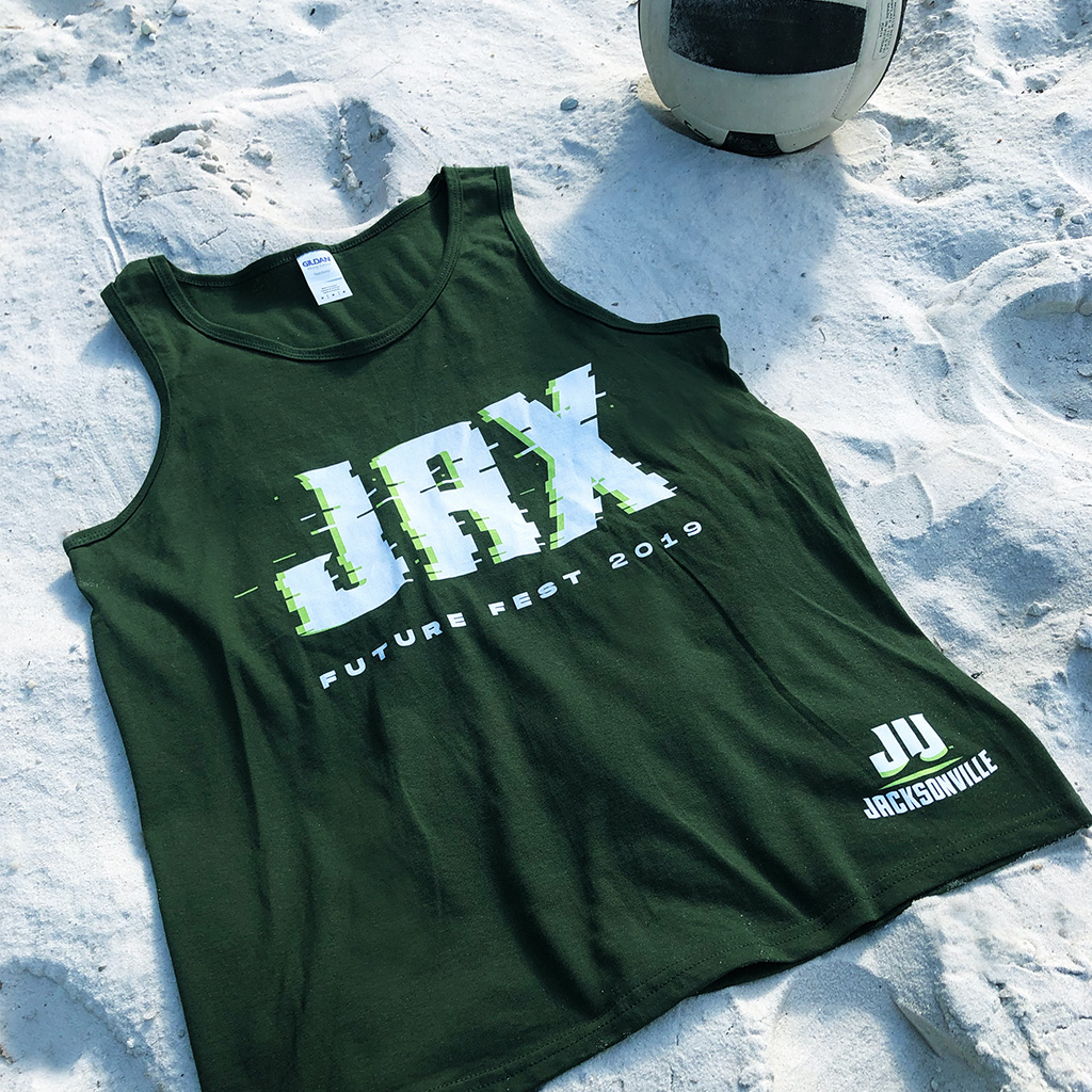 A green Future Fest tank top laying in the sand.