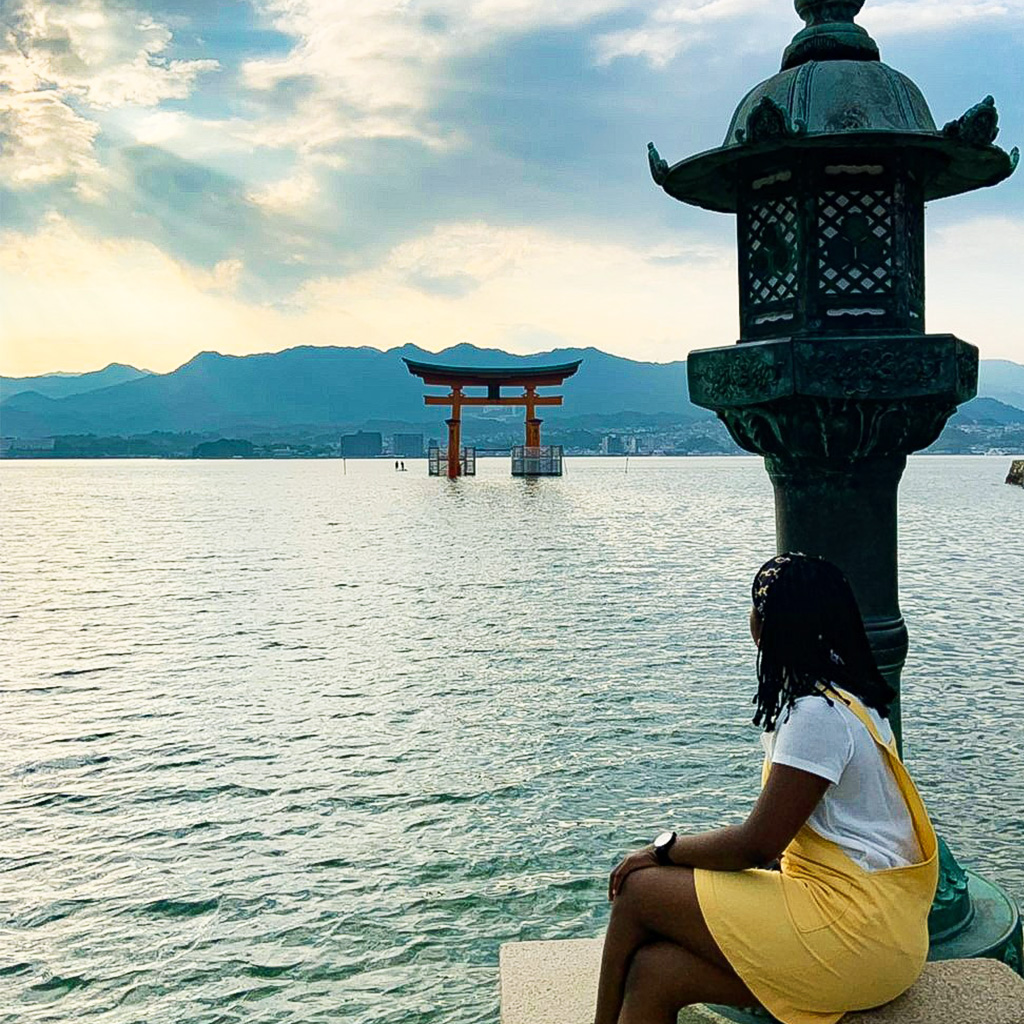 Natasha Ubani posing in front of the Great Torii, which is a shrine in the Hiroshima prefecture of Japan that is considered a "floating" gate because of it's location in the middle of the water