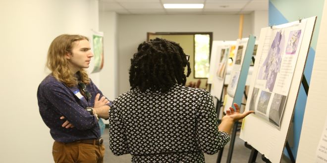 Caucasian male talking to an African American female talking about maps