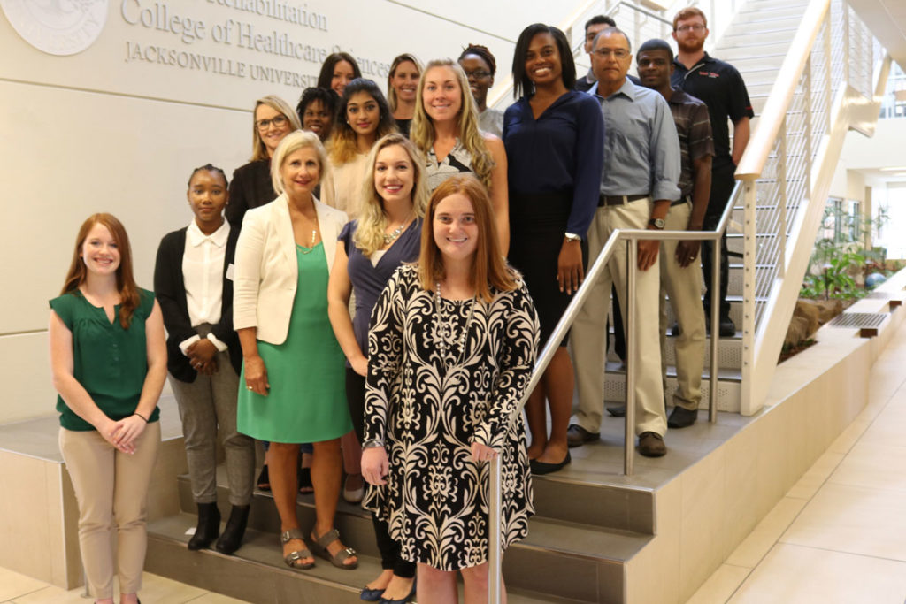 JU Clinical Mental Health Counseling 2018 graduating class on the steps of the Brooks Rehabilitation College of Healthcare Sciences staircase with Carolyn Smith and Sarah Willson 