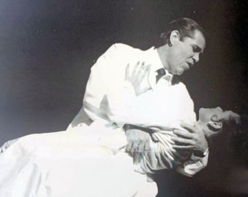 Leanza Cornett in JU play in late 1900's being dipped by a male actor while he sings to her onstage