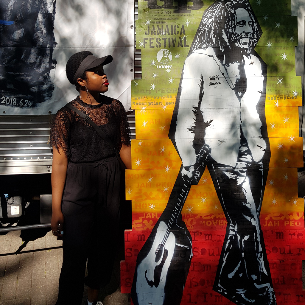 Natasha Ubani posing with a painting of Bob Marley at the Jamacian Fest in Tokyo, Japan