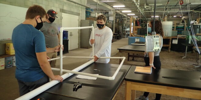 JU students fitting PVC piping to create a 