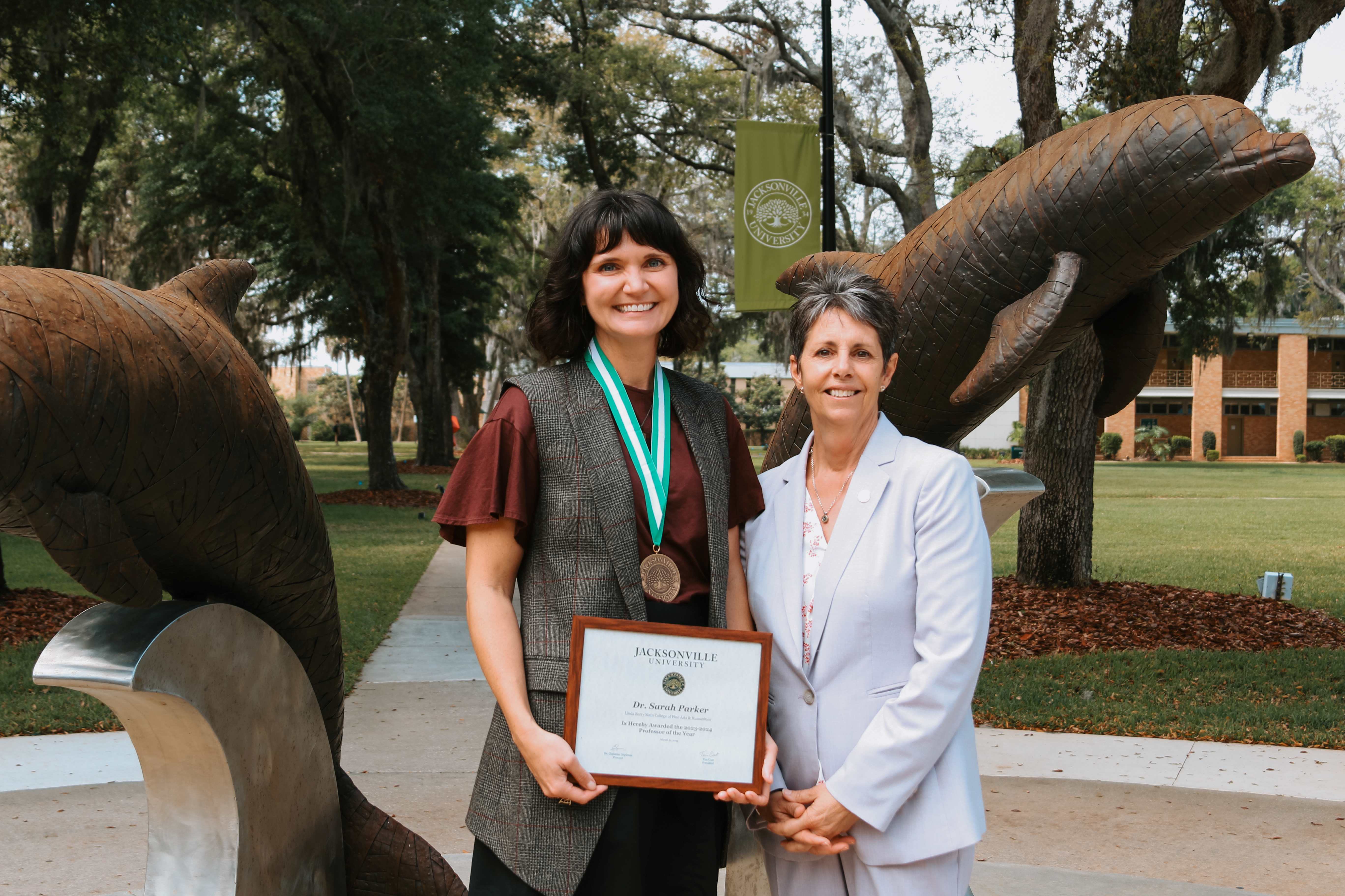 two women holding an award