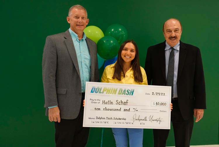 Dean Mark Tillman, Halle Schaf and Dr. James Trouten pose with a large check.