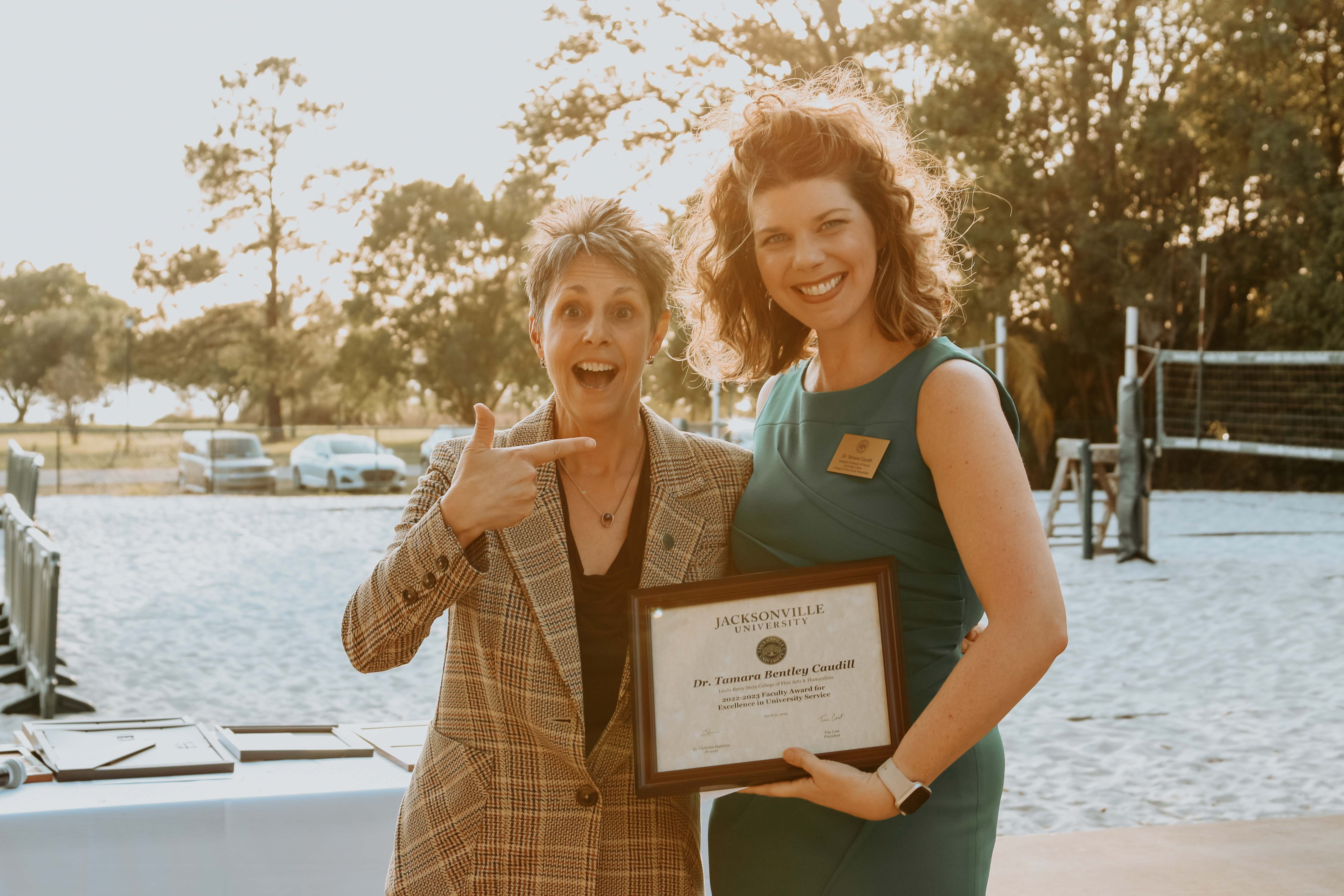 two women holding awards