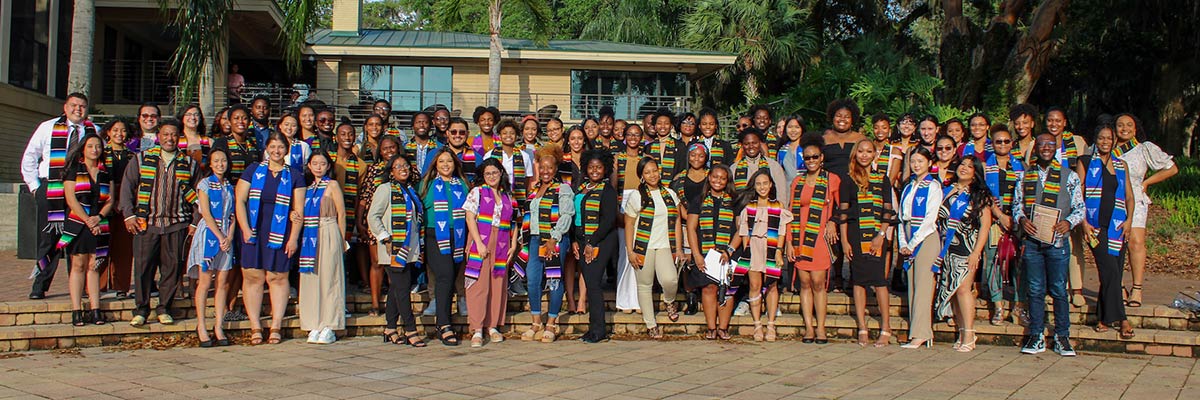 Students gathered behind the River House for a group photo at Multicultural Graduation.