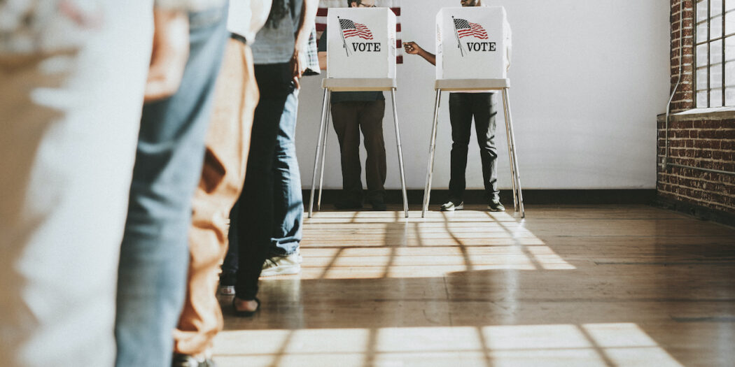 Stock image of people waiting in line to vote