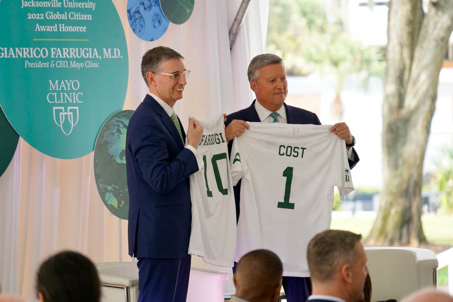 Dr. Farrugia and President Cost pose with matching, customized Jacksonville University jerseys.