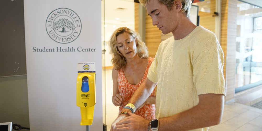 student uses sunscreen dispenser