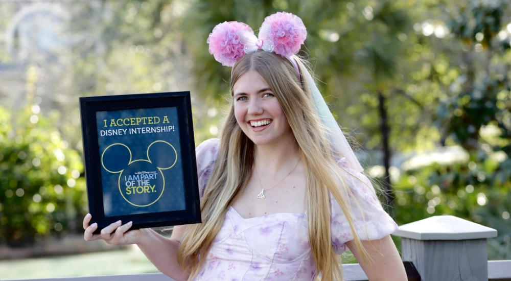 Skye student holding a framed poster signifying her acceptance into Disney internship program.