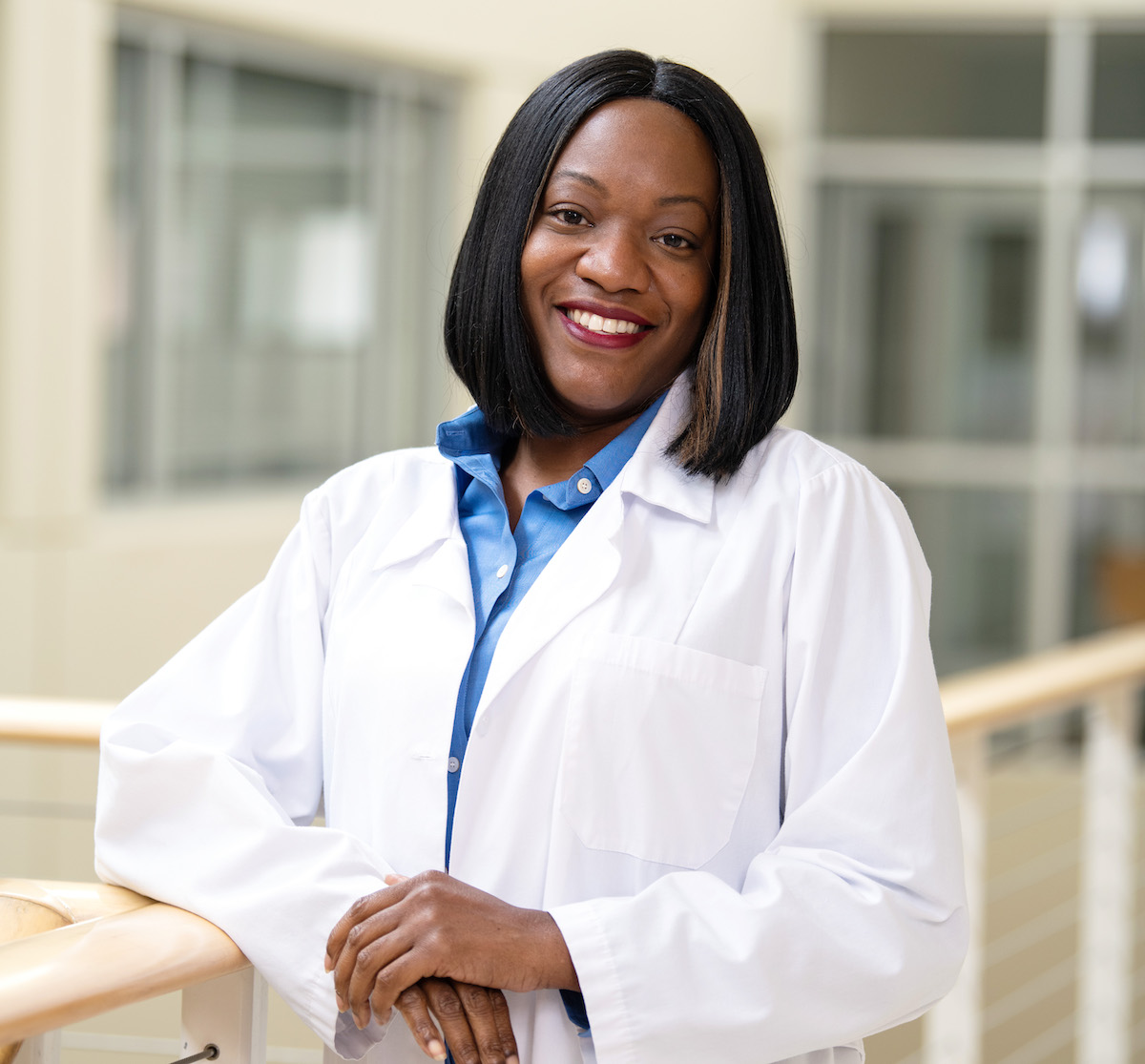 A nursing student in their coat posing for a photo.