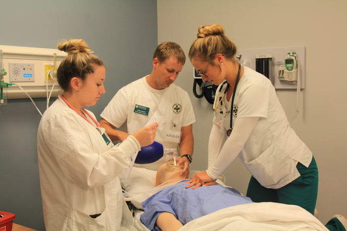 Three nursing students learning in the lab.