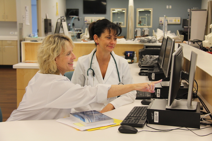 A team of healthcare professionals working at a computer.