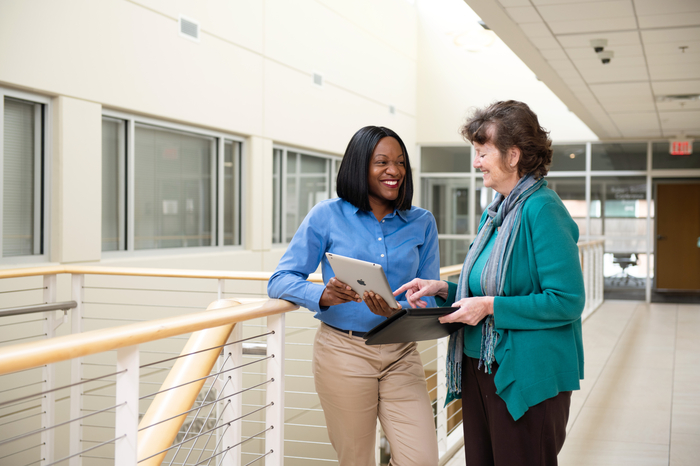 Two informatics nurses talking in a hallway.