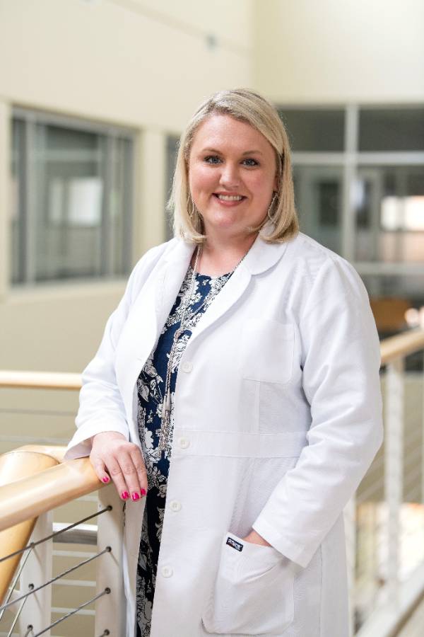 A nurse practitioner smiling for a photo.