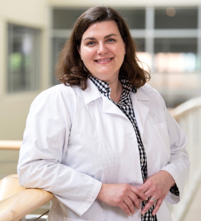 A nursing student looking at the camera for a photo in a hallway.