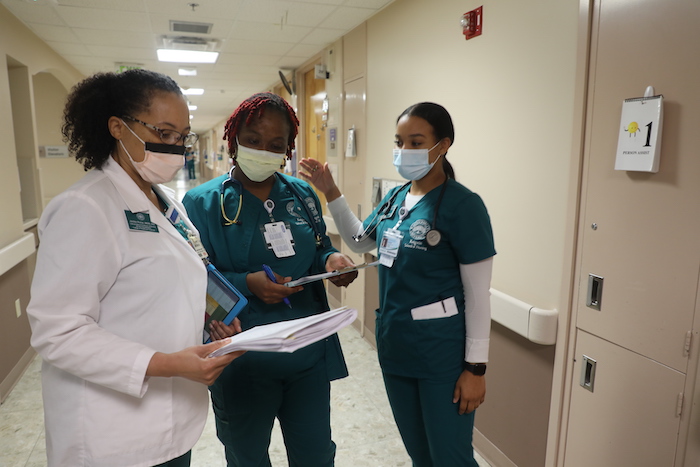 Three nursing students reviewing documents.