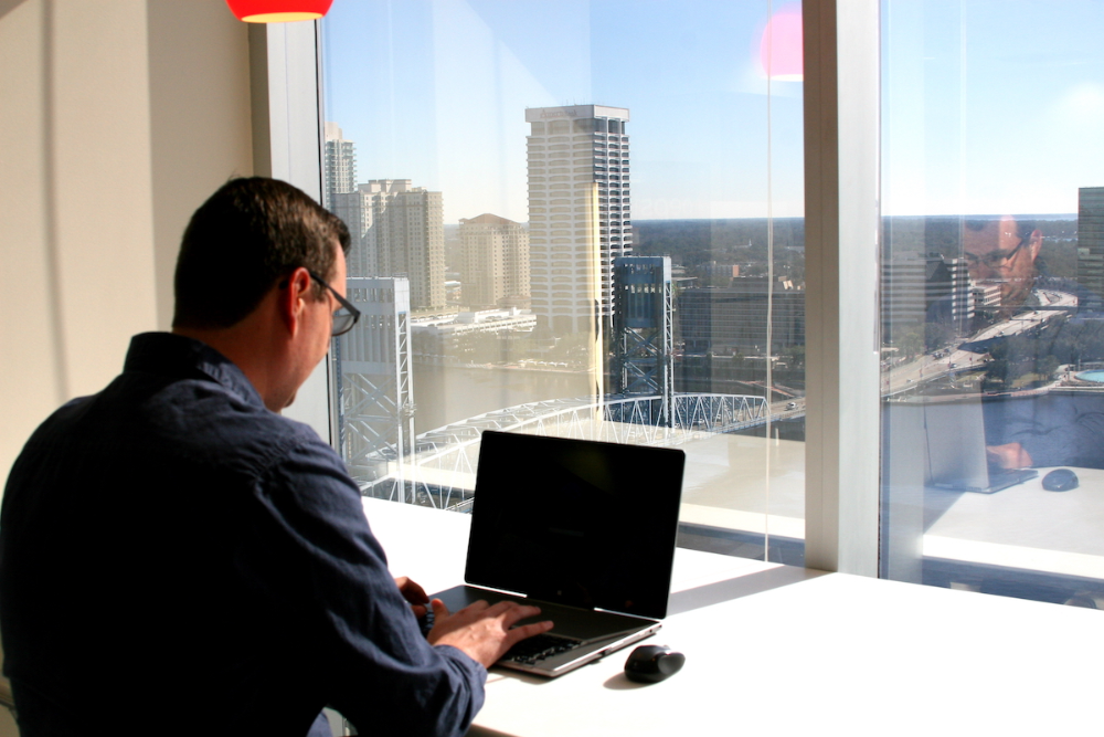 An online student sitting at his laptop at JU's Downtown location.